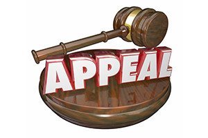 Appeal word in red letters on a wooden judge gavel