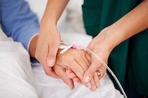 Closeup of nurse holding patients hand
