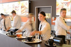 Busy waiter and waitrsses working at restaurant