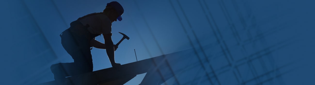 Worker hammering a long nail.