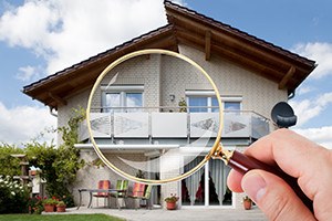 Person Hand With Magnifying Glass Over Luxury House