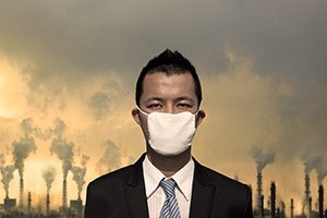 Sad businessman with mask and air pollution concept