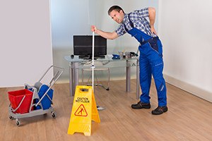 Male janitor suffering from back pain