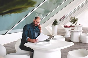 male entrepreneur talking on mobile phone during reviewing resume