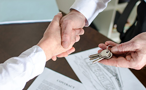 Estate agent giving house keys to customer
