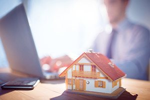 Estate agent using laptop at desk shot in studio