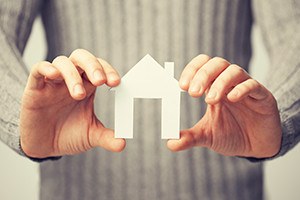 bright picture of man holding paper house