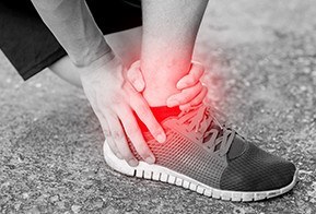 Runner touching painful twisted or broken ankle