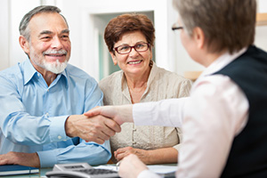 senior couple smiling with financial advisor