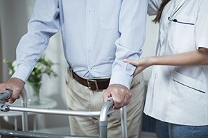 Disable man using walking frame during rehabilitation