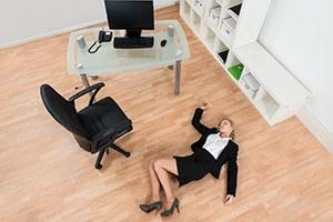 High Angle View Of Young Businesswoman Fainted On Floor In Office
